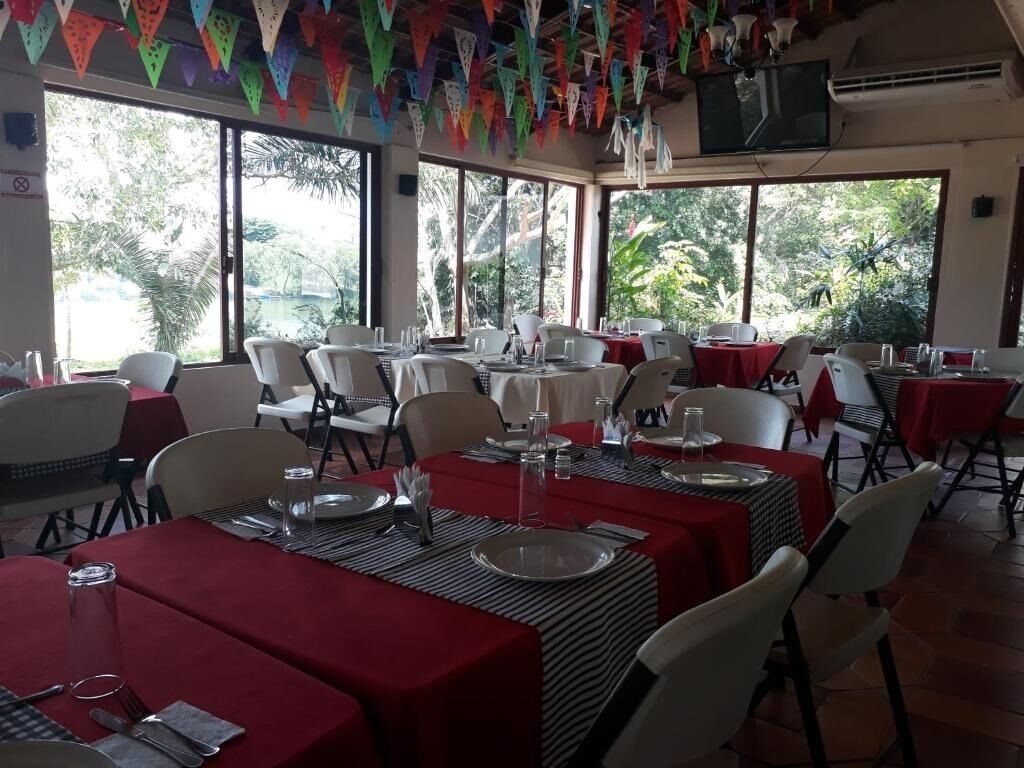 A restaurant with tables set for dining, large windows, and colorful decorations.