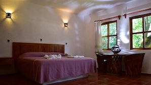 A bedroom with a wooden bed, a desk with a chair, and a window with curtains. - HOTEL VILLA BLANCA SUITES (San Juan Bautista Tuxtepec)