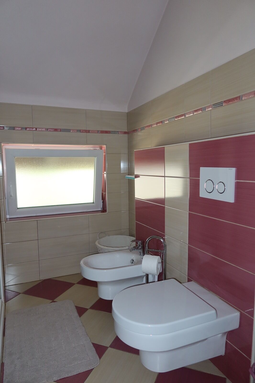 Un baño con inodoro, lavamanos y ventana.