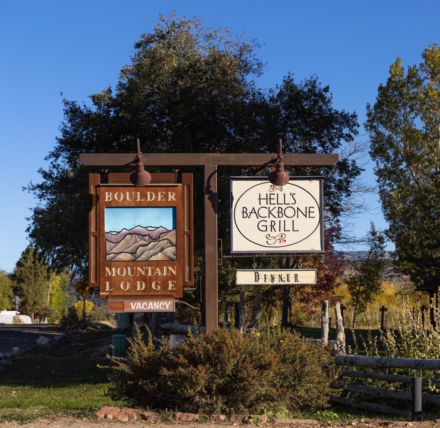 A sign for Boulder Mountain Lodge with a vacancy notice and a sign for Hell's Backbone Grill.