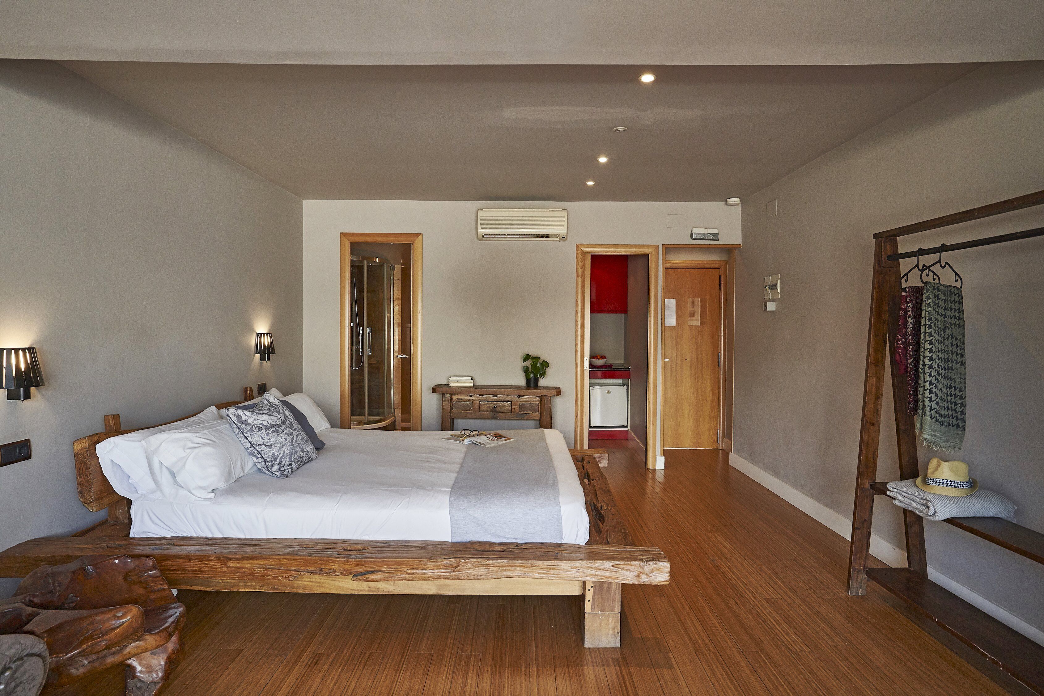 Une chambre à coucher avec un lit en bois, des tables de chevet, une armoire et un miroir.