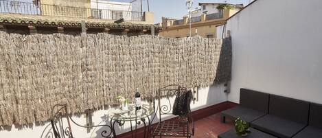 A patio with a table, chairs, and a sofa.