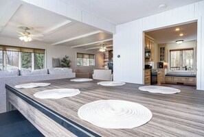 Moderni keittiö, jossa on suuri keittiösaareke, integroidut kaapit ja näkymä olohuoneeseen.