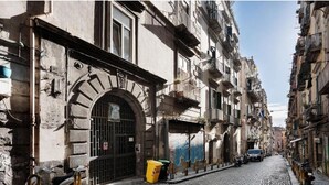 A cobblestone street lined with historic buildings, a scooter parked on the side, and a clear blue sky. - Cottage frm home (Napoli)