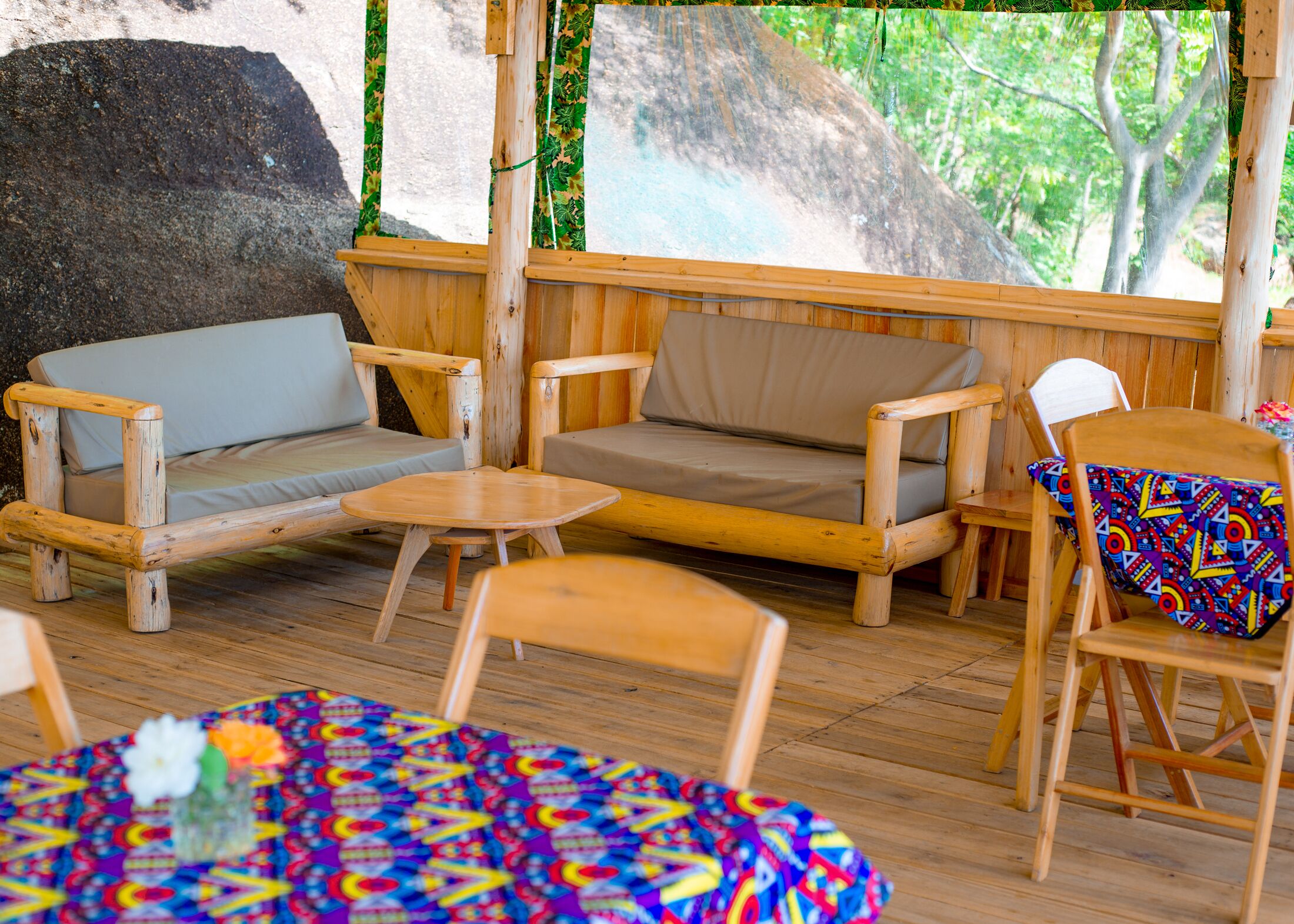 A wooden lounge area with a sofa, chairs, and a small table.