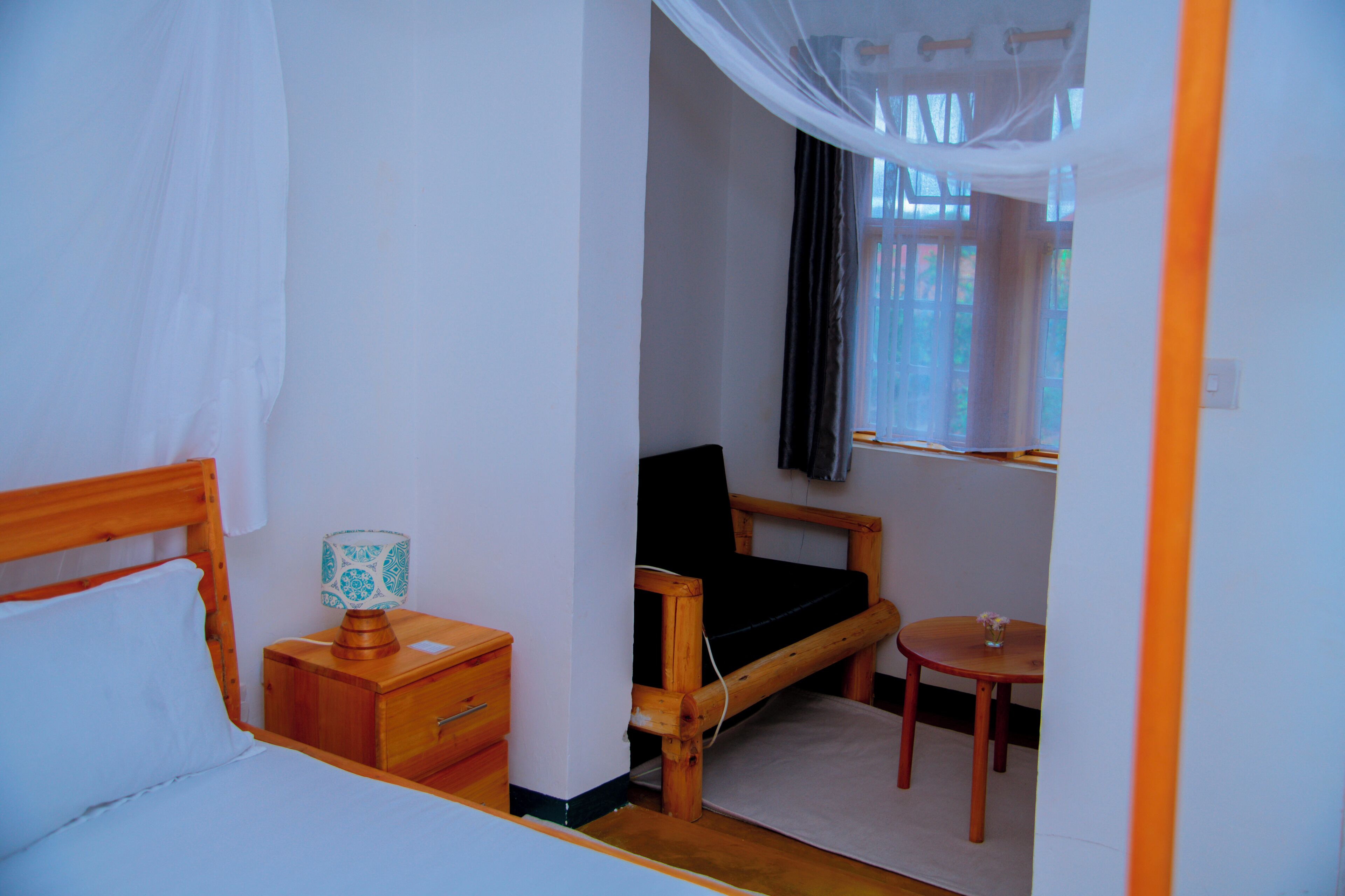 Una camera da letto con un letto, un comodino, una sedia e un tavolino con una tazza.