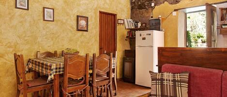 Una cocina acogedora con muebles de madera, una mesa de comedor y un sofá rojo.