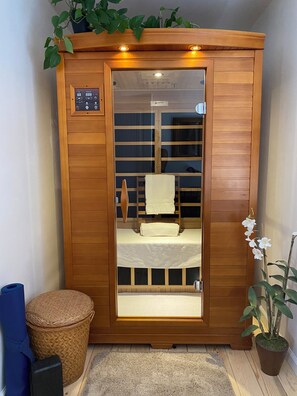 Een houten kast met een spiegel, een handdoek en een kleine plant.