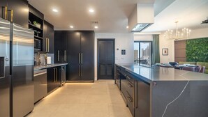 Een moderne keuken met donkere kastjes, roestvrijstalen apparatuur en een centraal eiland.