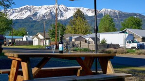 A picnic table with a mountain view, a speed limit sign, and a white truck in the background. - Blue Moon Retreat ~~ Spacious duplex unit with SAUNA and a stunning view (Joseph)