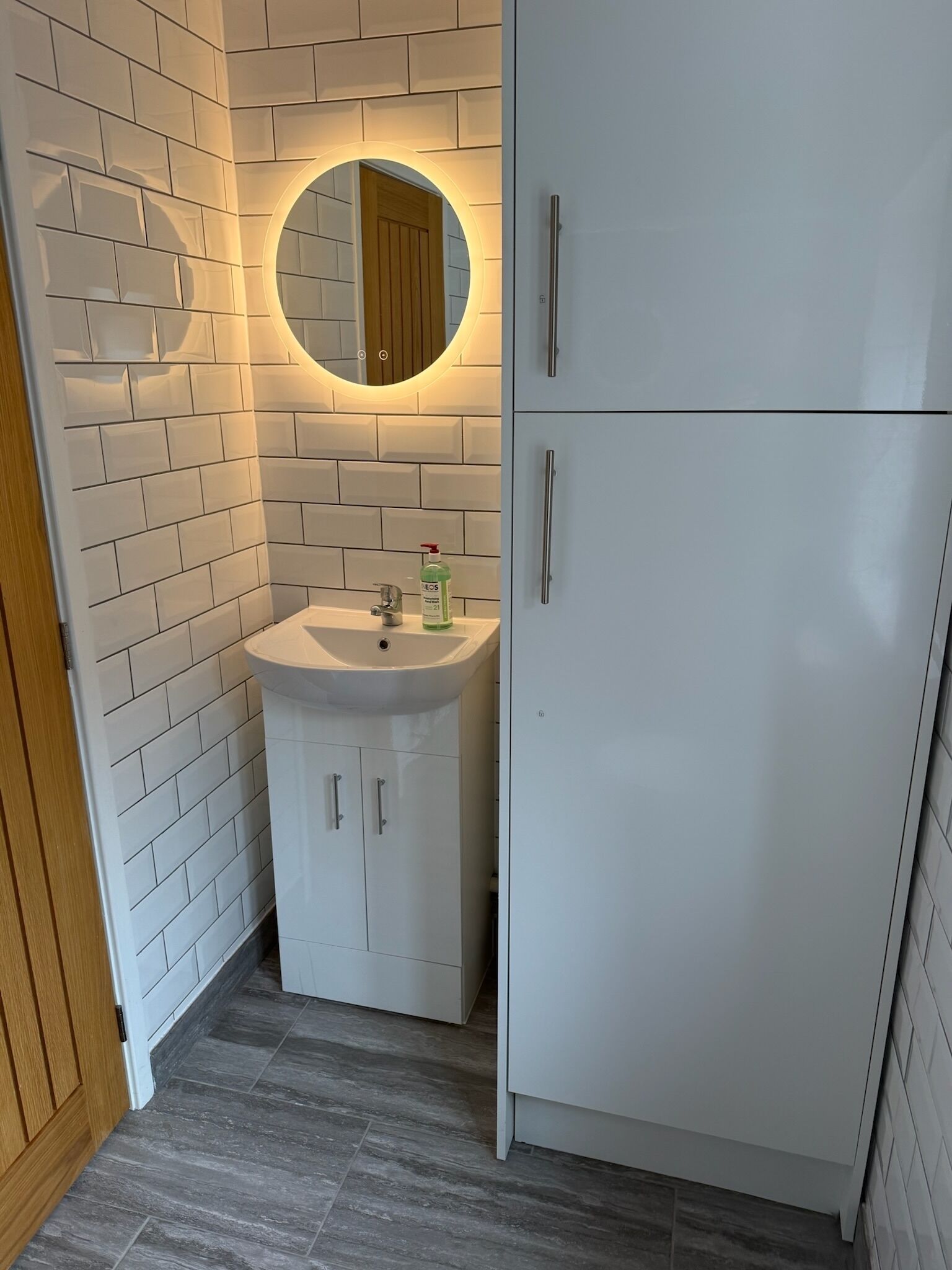 A bathroom with a white sink, a mirror, and a cabinet.