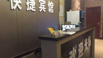 A reception desk with a sign that reads 'Happy Inn' and another sign with Chinese characters.