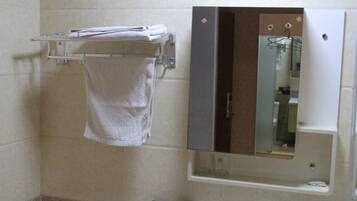 A bathroom with a towel rack, a mirror, and a toilet.