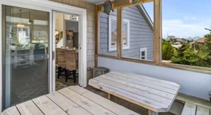 Relax in this serene outdoor space with a view of the surrounding neighborhood, featuring a comfortable chair and small table.