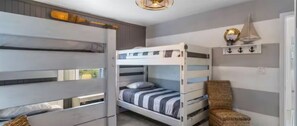 Cozy space for multiple guests, featuring bunk beds and a comfortable chair.