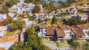 A coastal residential area with terracotta-roofed houses, a swimming pool, and a view of the sea. - Bz73 Geribá! Casa c/ piscina privativa 5 Suítes! (Búzios)
