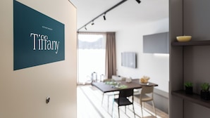 A modern interior with a dining area, a kitchen, and a living space. - Boutique Apartments By Annalisa (Nago-Torbole)
