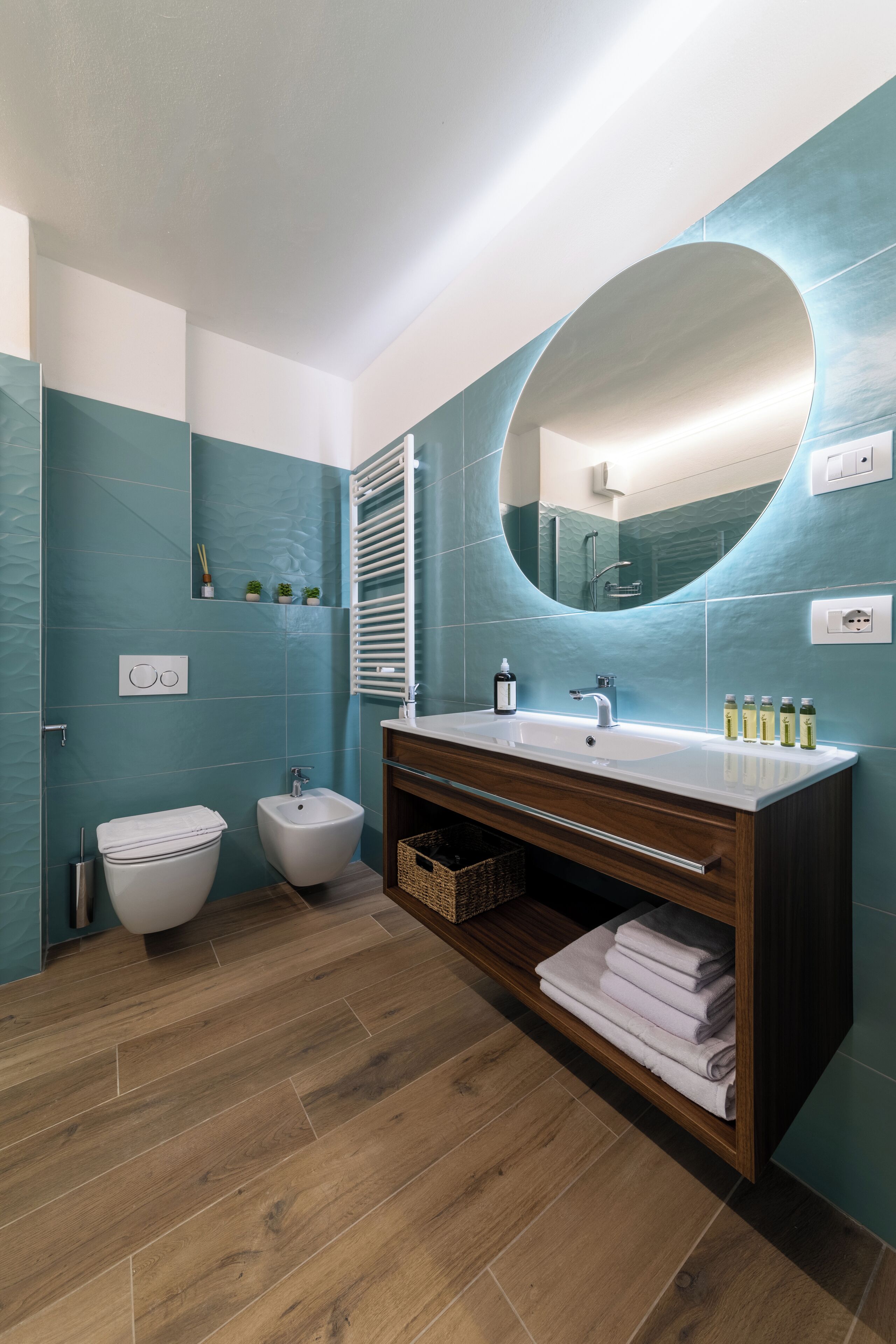 A modern bathroom with a large mirror, a sink, and a bidet.