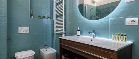 A modern bathroom with a large mirror, a sink, and a bidet.