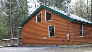 A wooden cabin with a green roof, two windows, and a chimney. - Handicap Cabin with hot tub ~ NO PETS (Clarington)