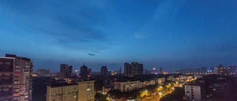 A cityscape at dusk with buildings, roads, and streetlights.