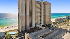 Ein Hochhaus-Hotel mit mehreren Stockwerken, einem Pool und Blick auf den Strand.