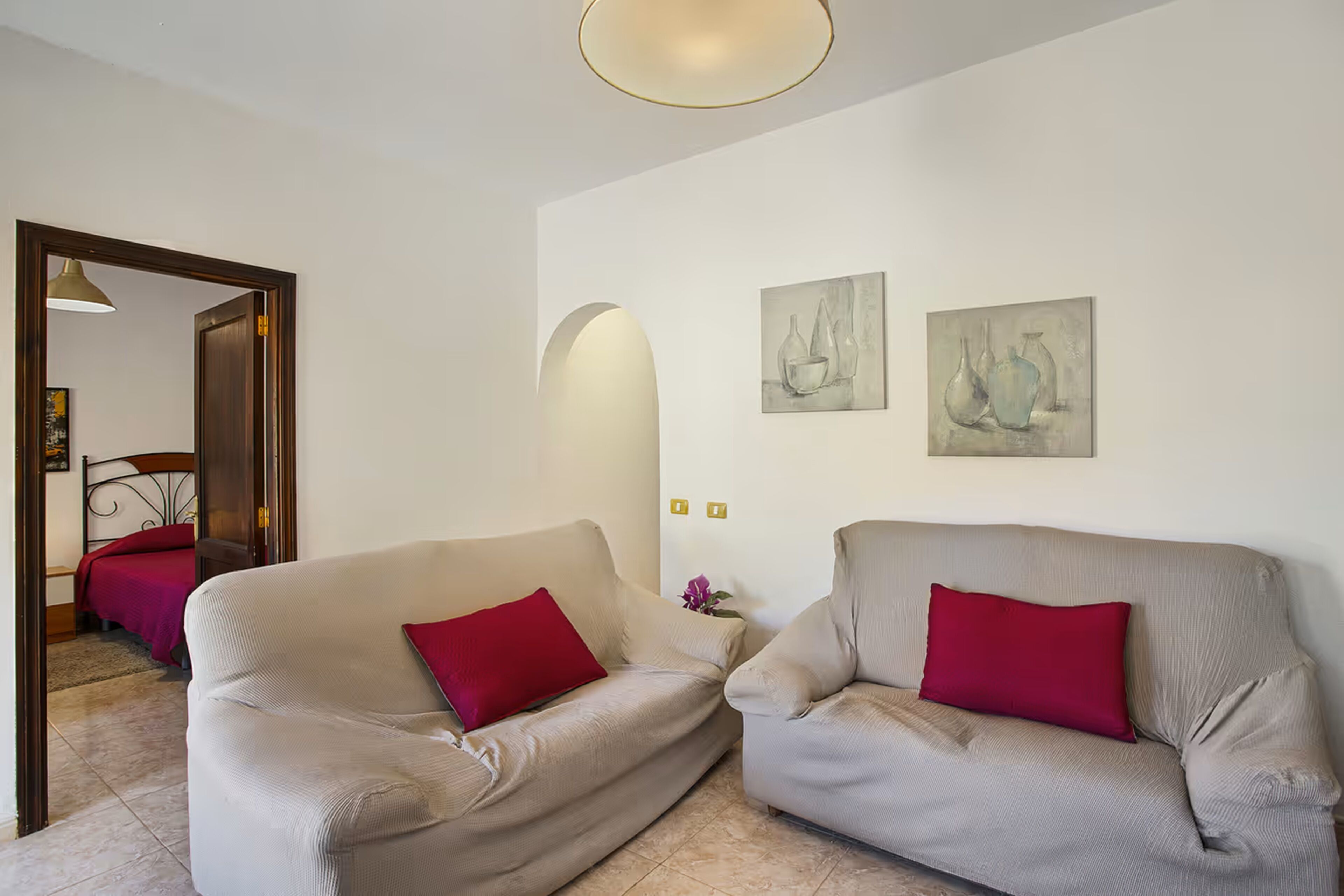 Ein Wohnzimmer mit zwei Sofas, einer Tür und zwei Wandgemälden.