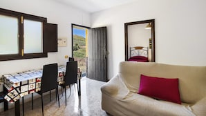 A room with a dining table, chairs, a sofa, and a large mirror. - House Altos de Gáldar (Galdar)