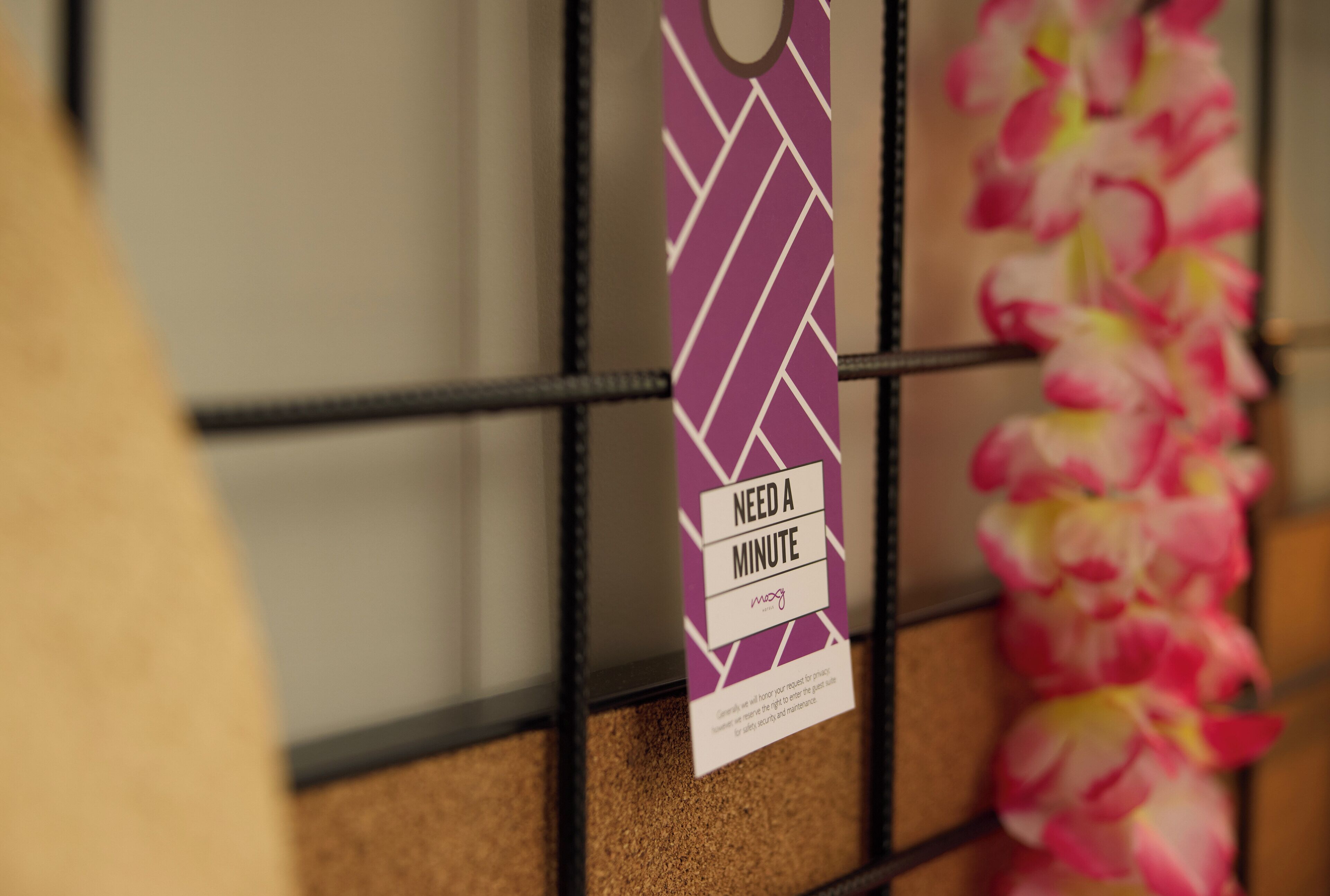 A tag hanging on a metal rack with the text 'NEED A MINUTE' and a logo.