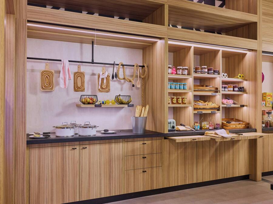 Una cocina moderna con armarios de madera, estantes abiertos para especias y utensilios, y una encimera negra.