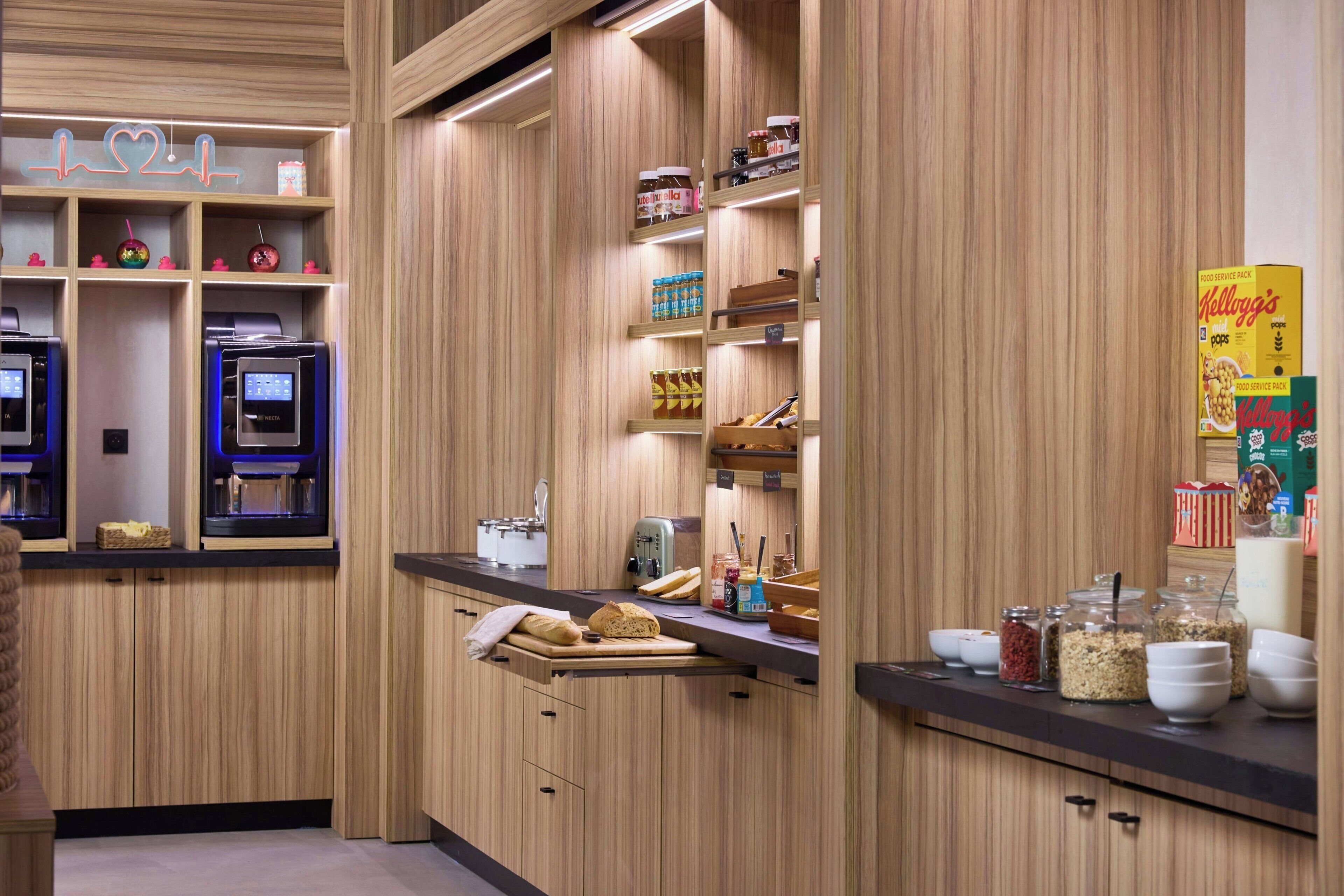 A modern kitchen with wooden cabinetry, built-in appliances, and various food items on shelves.