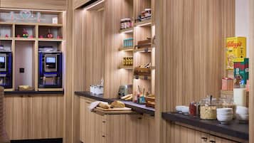 A modern kitchen with wooden cabinetry, built-in appliances, and various food items on shelves.