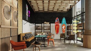 Un interior moderno con un separador de madera, un comedor y tablas de surf.