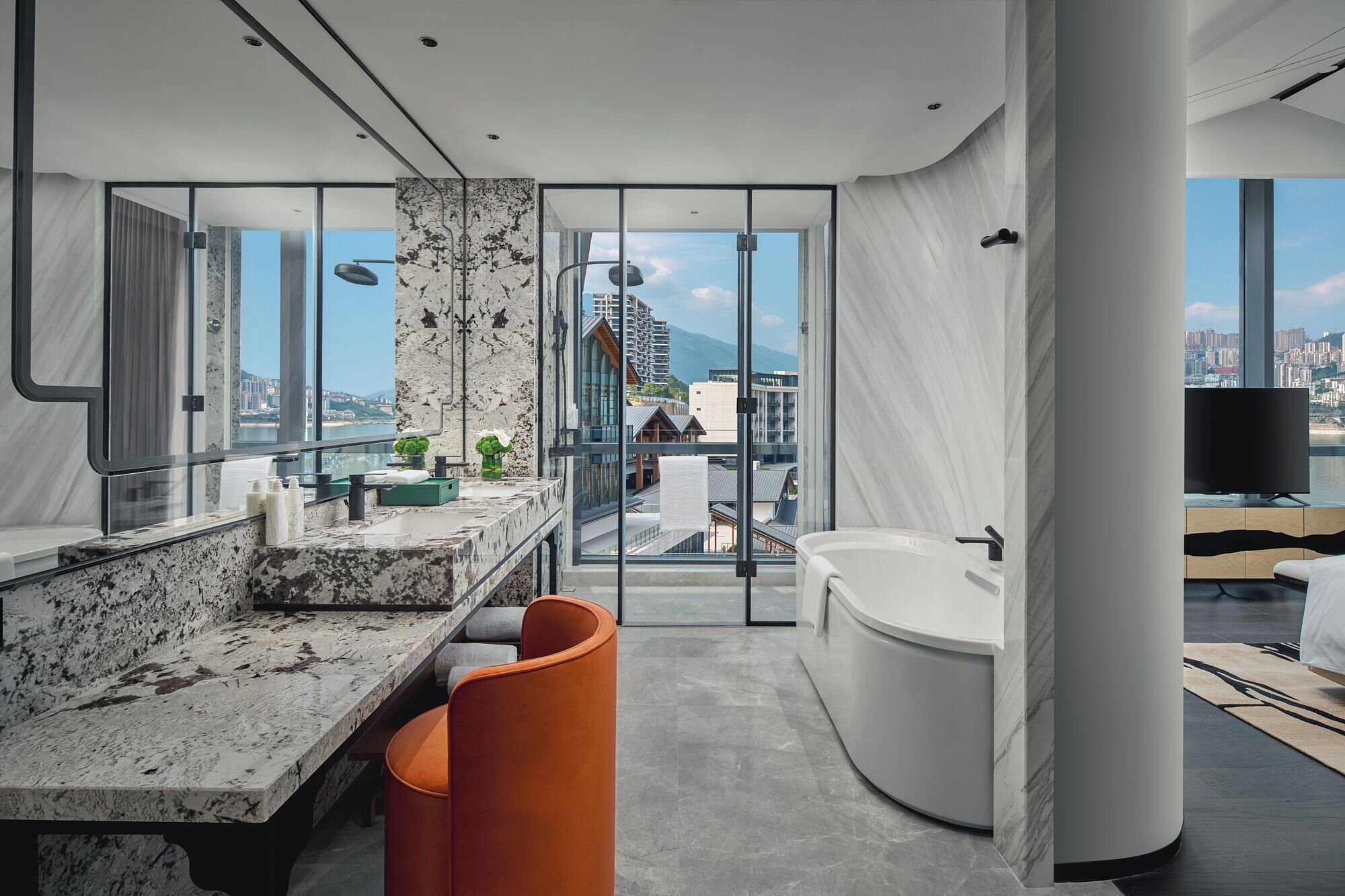 Une salle de bain moderne avec un meuble-lavabo en marbre, une baignoire et une vue sur le paysage urbain.