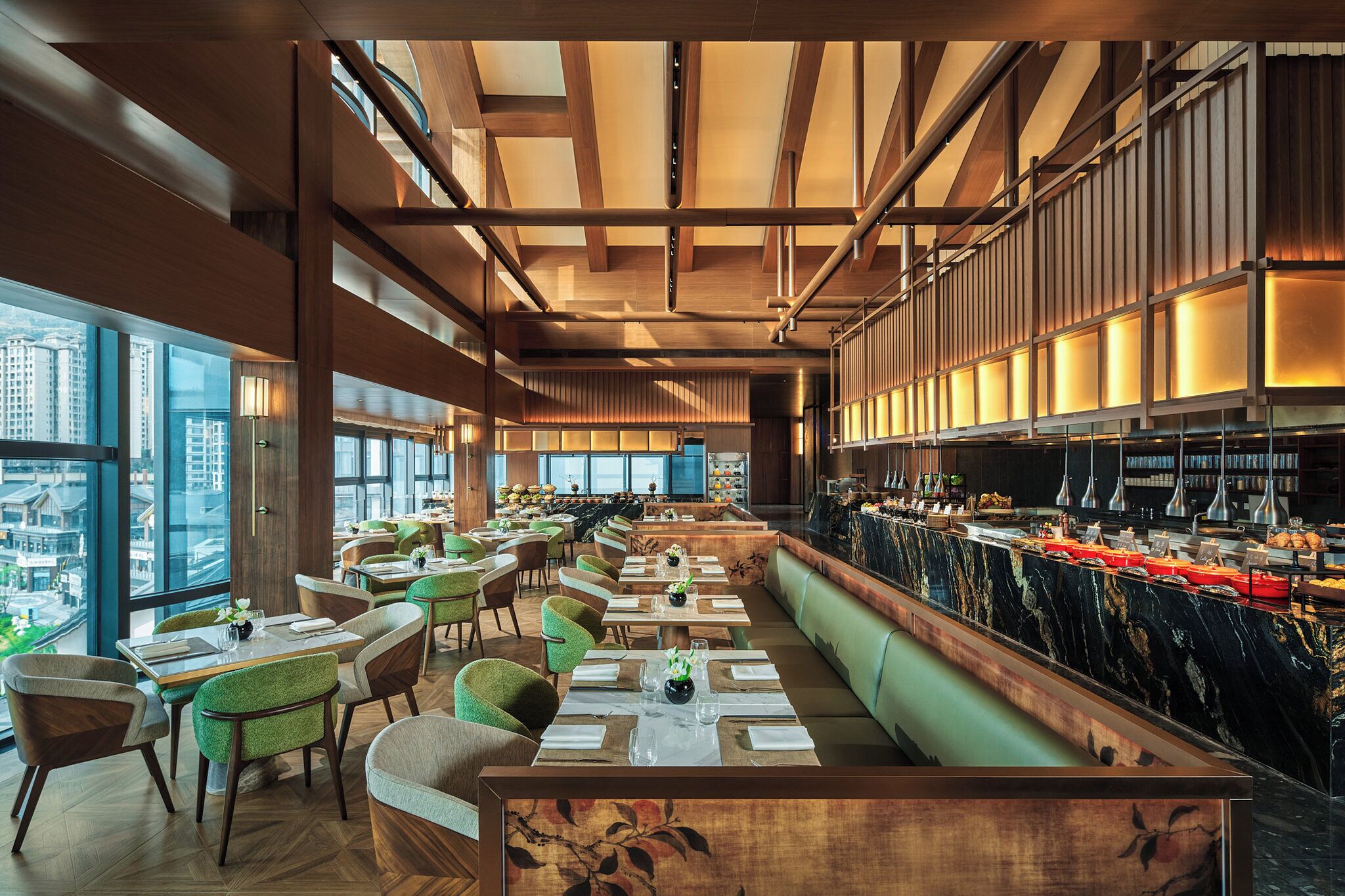 Un restaurante moderno con techos altos, vigas de madera y una larga barra con protector de mármol.
