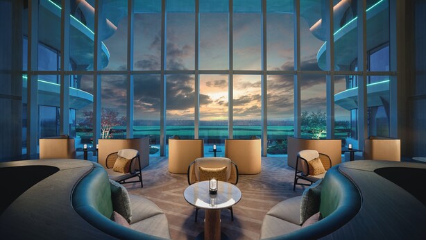 Un salón moderno con amplios ventanales, asientos cómodos y vistas al atardecer.