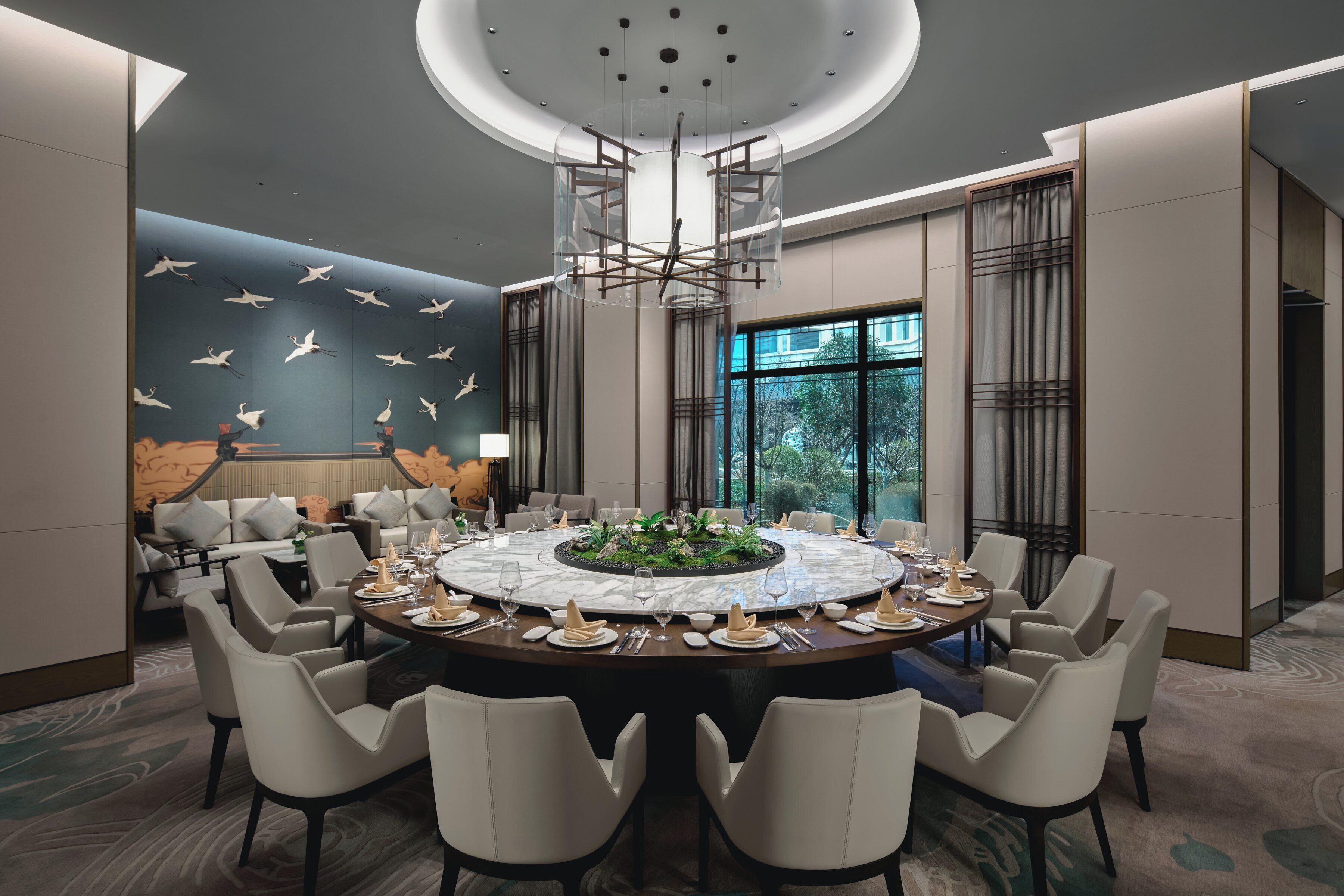 A modern dining room with a round table set for six, surrounded by six chairs.