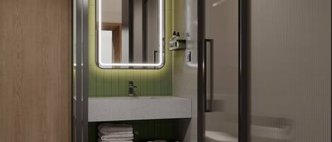 Un baño moderno con tocador de madera, pared de azulejos verdes y espejo con iluminación integrada.