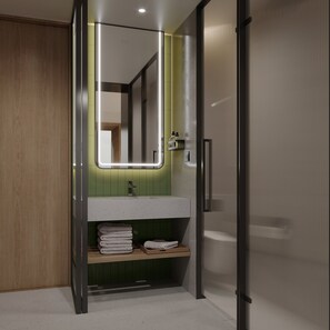 Un baño moderno con tocador de madera, pared de azulejos verdes y espejo con iluminación integrada.