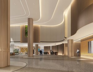 Un'ampia hall con soffitti alti, grandi colonne e un banco reception centrale.