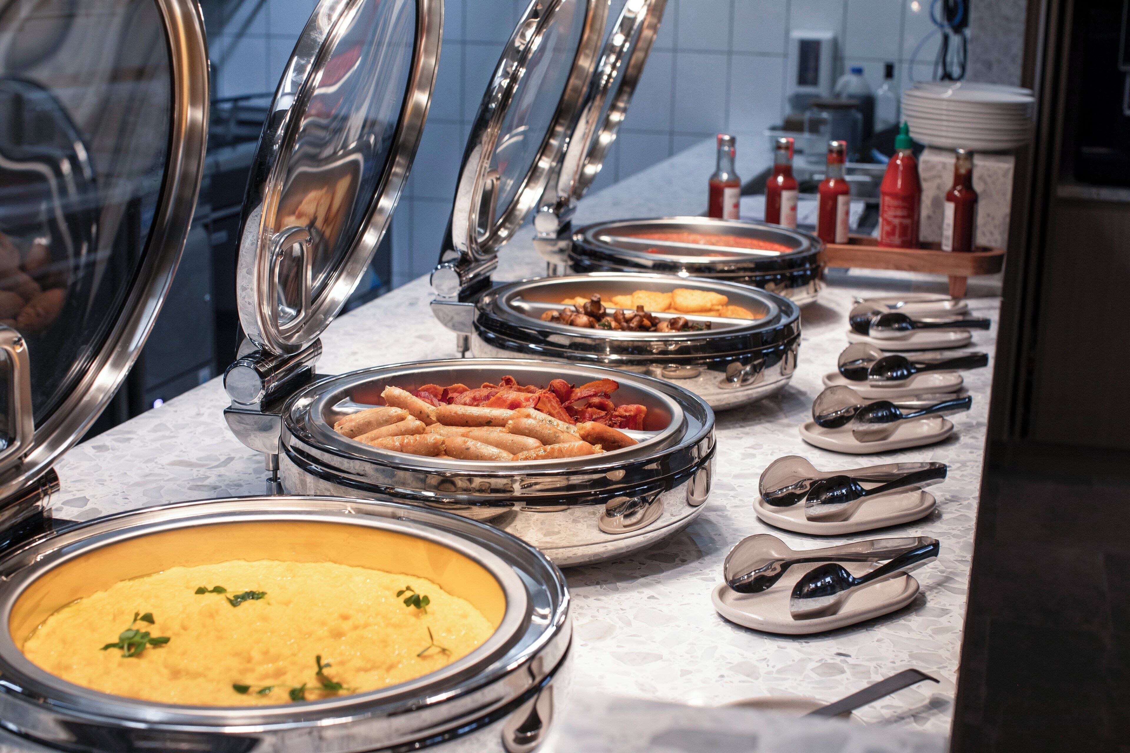 A buffet with various food items and condiments.