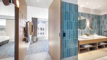 Un baño moderno con un espejo grande, dos lavamanos y un revestimiento de azulejos azules.