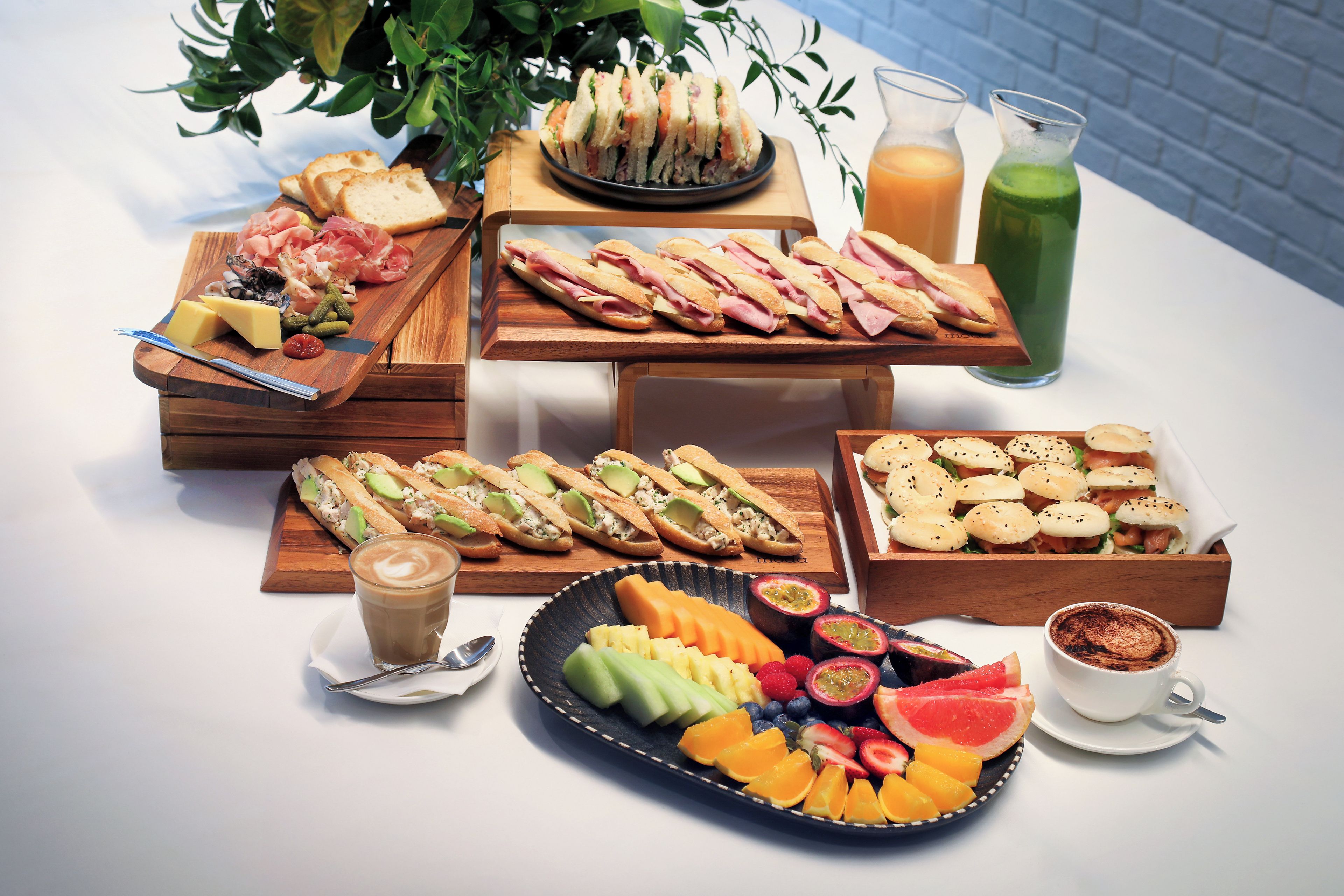 Une variété d’aliments, notamment des sandwichs, des fruits et des boissons, disposés sur une table.