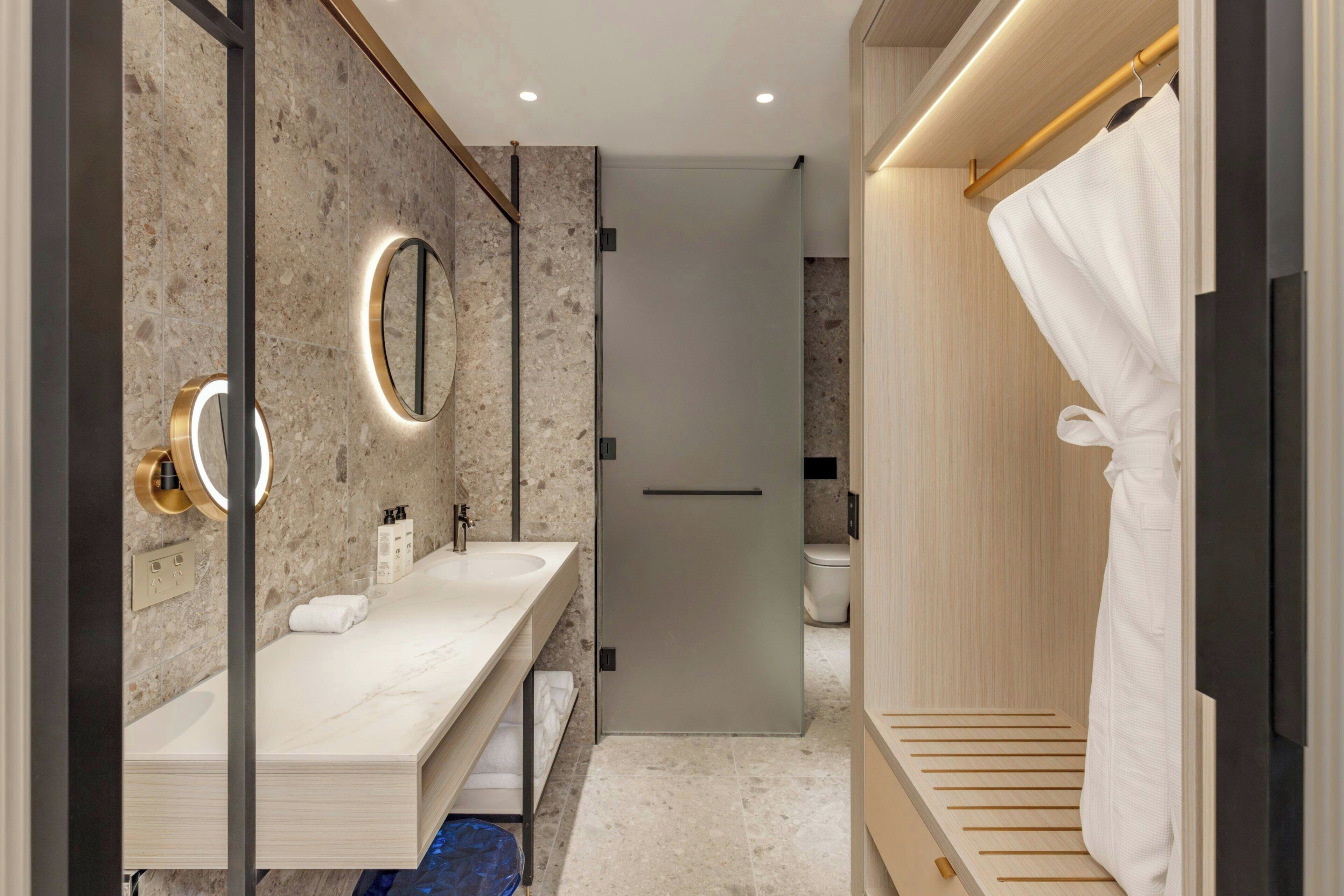 Une salle de bain moderne dotée d’un meuble-lavabo double, d’un grand miroir et d’une douche à l’italienne.