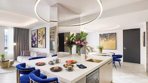 Una cocina moderna con una isla central, taburetes de bar y un comedor.