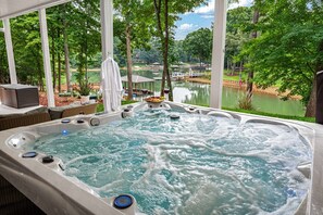 Un bain à remous avec vue sur un lac et des arbres.