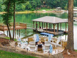 Une terrasse au bord du lac, dotée de chaises Adirondack, d’un foyer et d’un belvédère.
