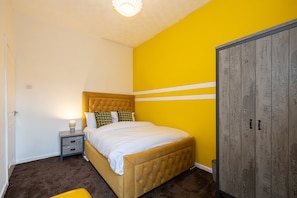 A bedroom with a bed, bedside table, and wardrobe. - Barnes Street Terrace (Accrington, Lancashire, United Kingdom)