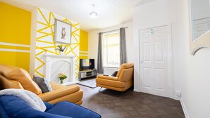 A living room with a sofa, armchair, and fireplace. - Barnes Street Terrace (Accrington, Lancashire, United Kingdom)