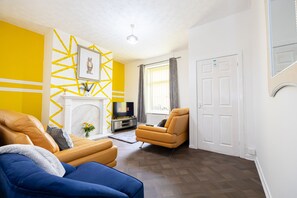 A living room with a sofa, armchair, and fireplace. - Barnes Street Terrace (Accrington, Lancashire, United Kingdom)